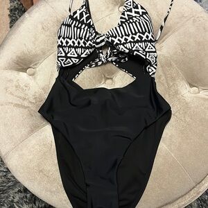 Black and white one piece swim suit w cutouts in front & back, adjustable straps